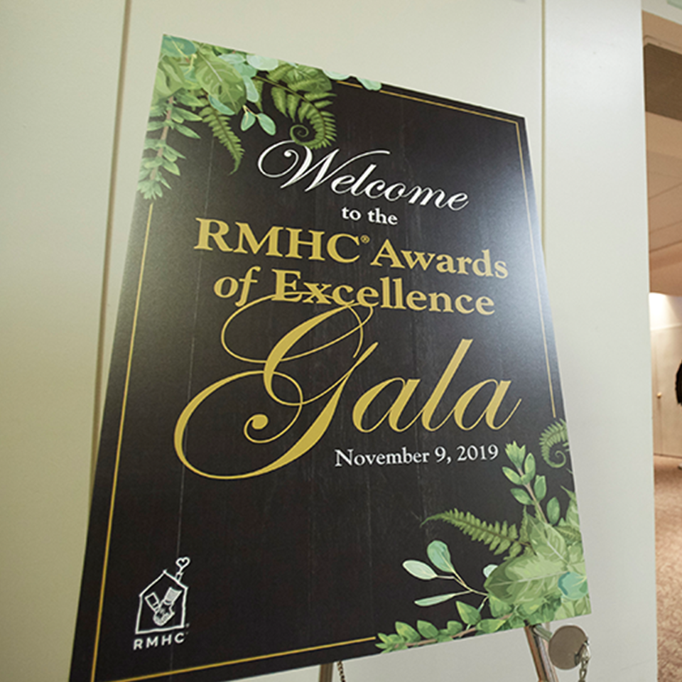 A gala poster, reads, "Welcome to the RMHC Awards of Excellence Gala, November 19, 2019"
